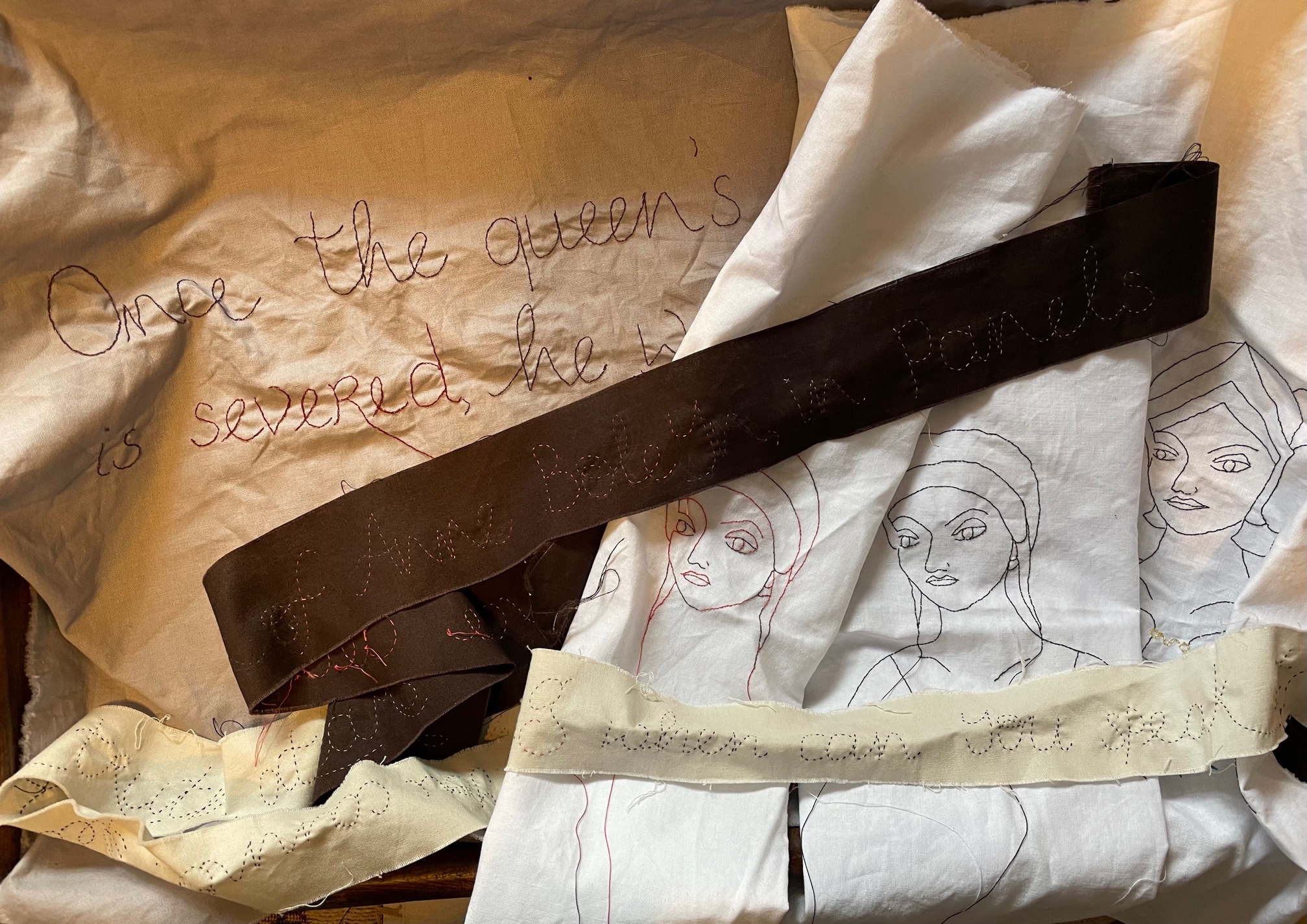 A selection of embroidered pieces, wording and three heads of a woman. The words 'Anne Boleyn in panels', 'when can you speak', and 'Once the queen's' and 'is severed' are visible.