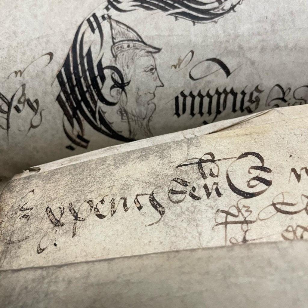 A bearded face doodled on a roll of parchment