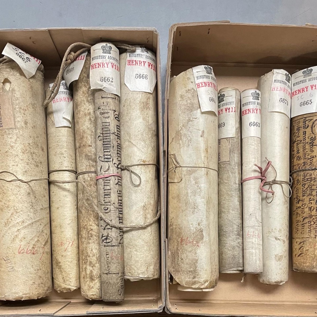 Two cardboard boxes containing rolls of parchment labelled Henry VIII