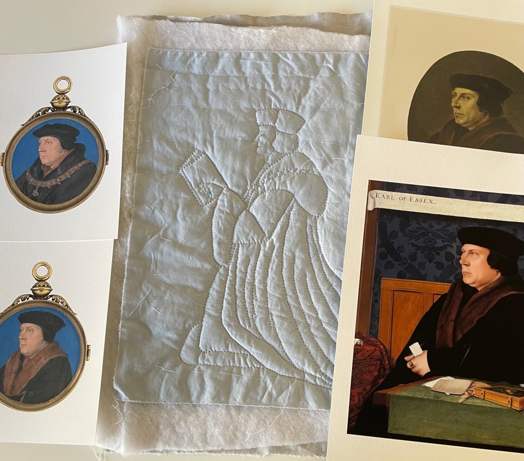 A quilted picture of a kneeling Thomas Cromwell, holding a book. He is surrounded by four painted portrait prints of differing sizes and styles.