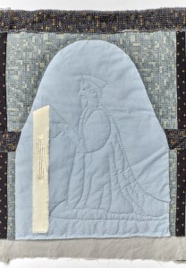 A quilted picture of Rafe Sadler, kneeling under an arch and holding a book. A strip of fabric with text attached falls from the book. 